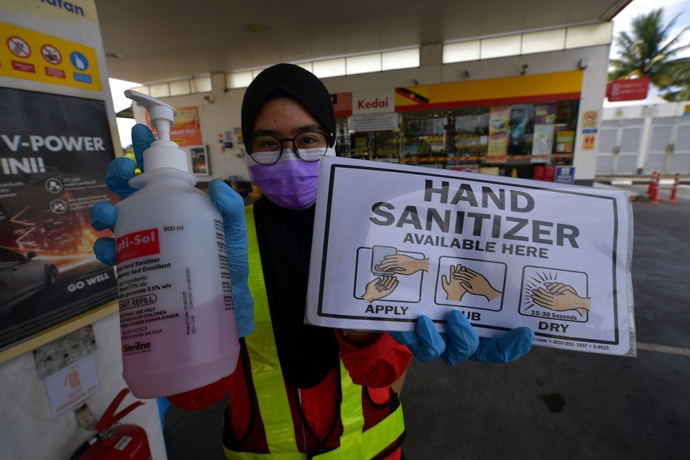 A gas station supervisor at Jalan Sultan Tengah in Petra Jaya shows the hand sanitiser provided at the station to protect from Covid-19, in Kuching March 16, 2020. u00e2u20acu201d Bernama pic