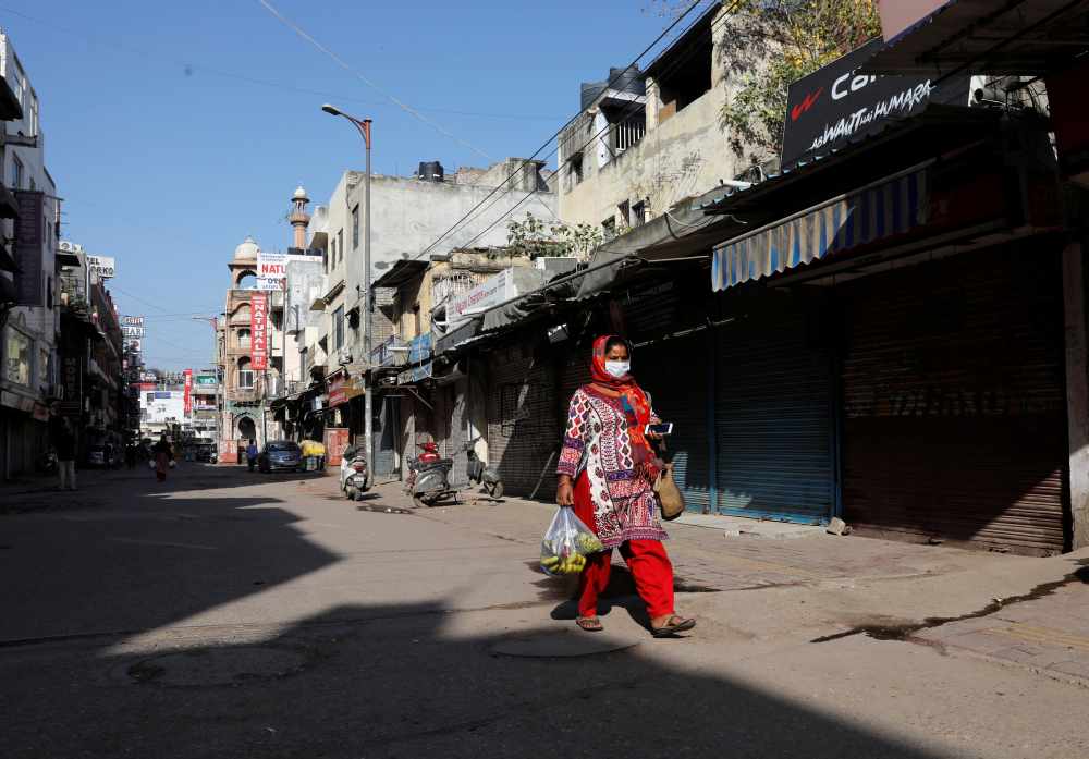 A woman walks along a near-empty street during a lockdown amid a coronavirus disease outbreak in New Delhi March 25, 2020. u00e2u20acu2022 Reuters pic