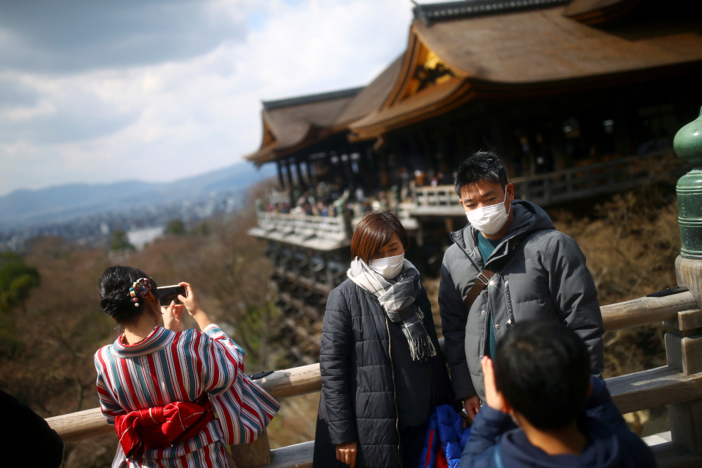 A couple, wearing protective masks following an outbreak of the coronavirus disease, poses for a photo at Kiyomizu-dera Buddhist temple in Kyoto, Japan March 15, 2020. u00e2u20acu201d Reuters pic 