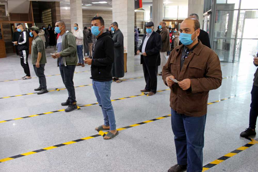 People wear protective masks, as part of precautionary measures against coronavirus disease, as they stand in a queue at a bank in Misrata, Libya March 22, 2020. u00e2u20acu2022 Reuters pic 