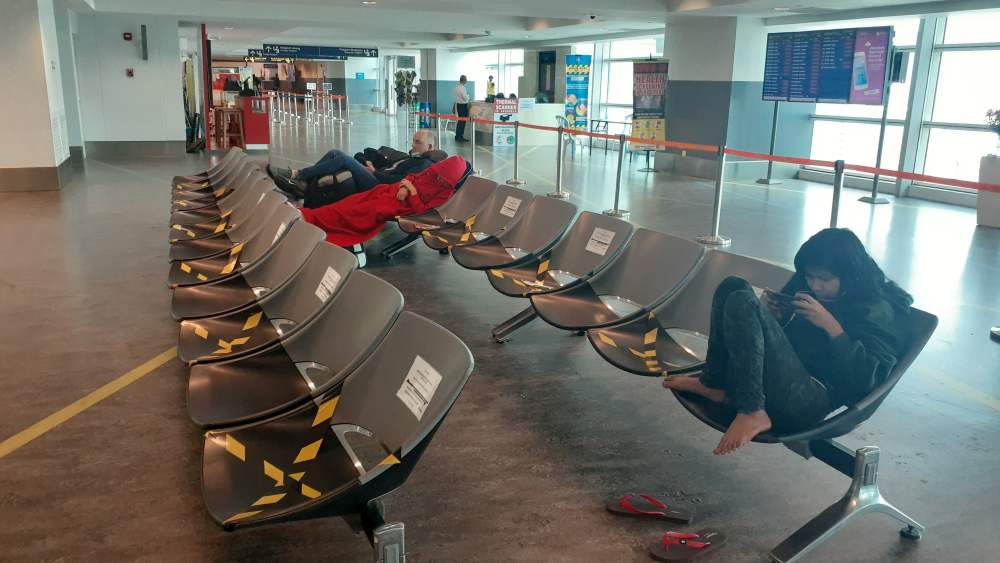 Stranded tourists sit in chairs at the transit area of KLIA2, after they were returned from Thailand due to new health certificate requirements amid coronavirus disease epidemic, in Sepang March 24, 2020. u00e2u20acu2022 Handout via Reuters