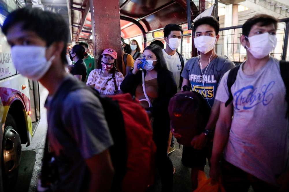 People wearing protective masks struggle to maintain social distancing as they wait for a bus on the first work day in the country's capital since the lockdown to contain coronavirus, in Quezon City, Metro Manila March 16, 2020. u00e2u20acu2022 Reuters pic