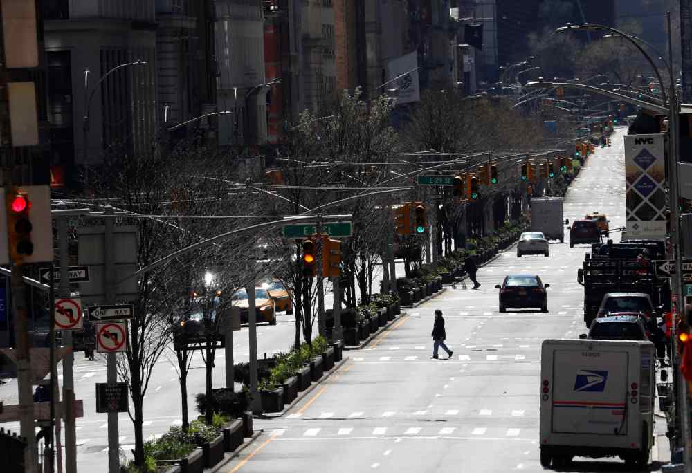 A woman crosses a nearly empty Park Avenue in midtown Manhattan during the outbreak of the coronavirus disease in New York March 24, 2020. u00e2u20acu2022 Reuters pic