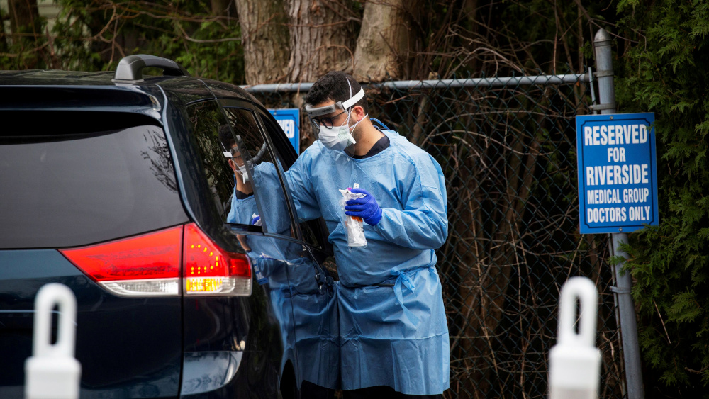 A worker in protective clothing tests a person in a car at a testing center for Covid-19 at Riverside Medical Group in Secaucus, New Jersey, US, March 18, 2020. u00e2u20acu201d Reuters pic