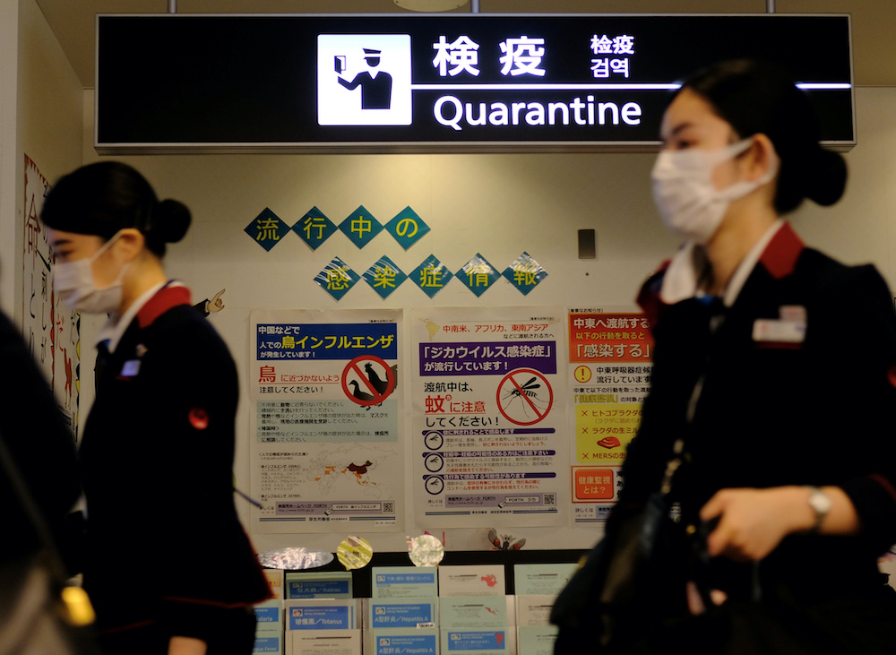 Airline employees wearing protective face masks, following an outbreak of the coronavirus disease (COVID-19), pass the Quarantine Counter at Narita Airport in Tokyo, Japan, March 14, 2020. u00e2u20acu201d Reuters picnn