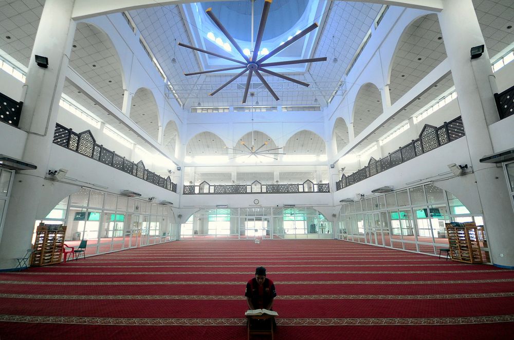 A mosque official reading the Quran while awaiting the time for Asar prayer at the Al-Munawwarah Mosque in Shah Alam , March 15, 2020. u00e2u20acu201d Bernama pic