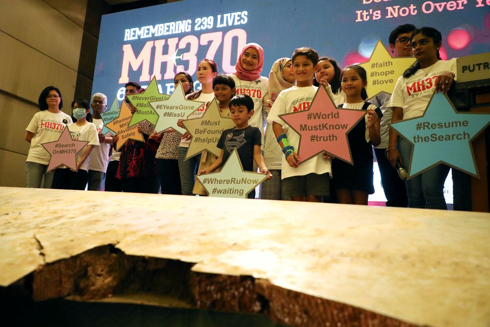 Family members of the victims pose for a group picture with a debris of the missing Malaysia Airlines flight MH370 during its sixth annual remembrance event in Putrajaya, March 7, 2020. u00e2u20acu201d Reuters pic