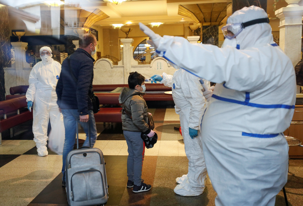 Medical staff take the body temperature of passengers, including Russian citizens, who are evacuated by train to Russia after Ukrainian authorities shut the country's borders amid the spread of coronavirus disease (Covid-19), at the Central Railway Statio
