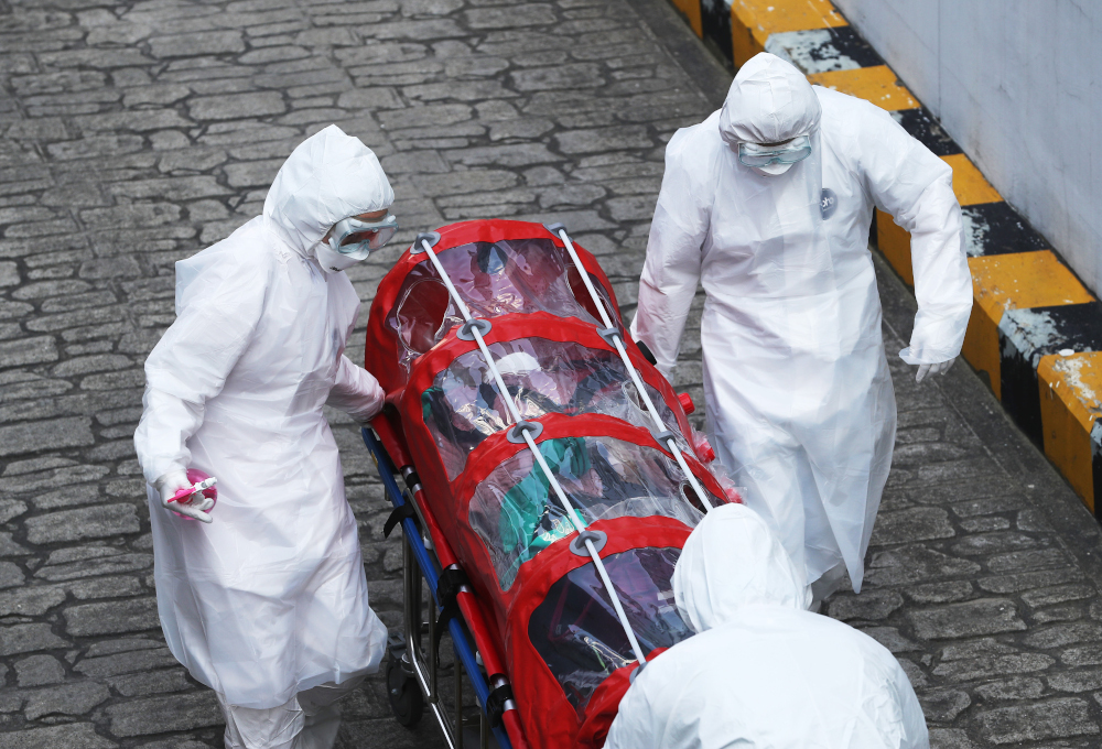 Medical staff members wearing protective gear carry a patient infected with the Covid-19 virus at a hospital in Seoul March 8, 2020. u00e2u20acu201d AFP pic 