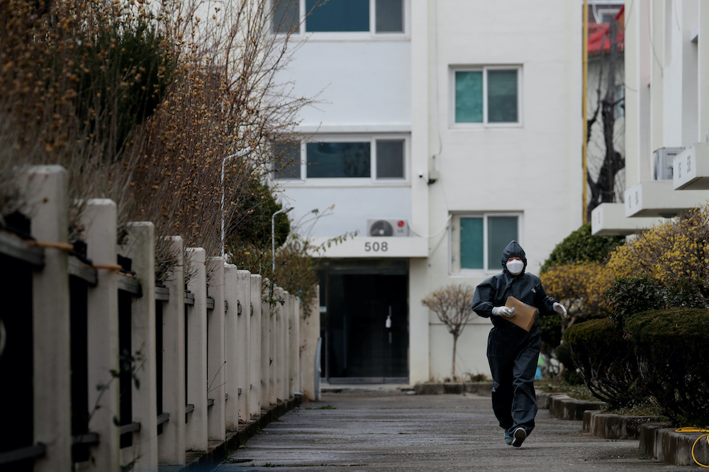 A worker in protective gear makes her way to an apartment building which has entered cohort isolation after a mass infection was reported amid the rise in confirmed cases of coronavirus disease (COVID-19) in Daegu, South Korea, March 7, 2020. u00e2u20acu201d Reuters 