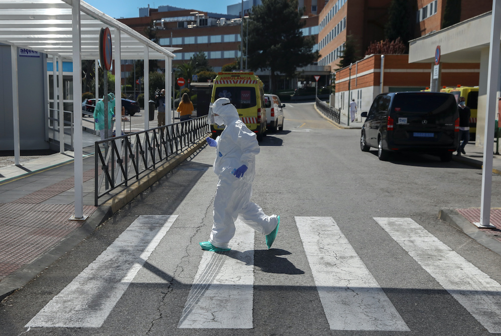 A healthcare worker wearing protective face mask and suit walks near the emergency unit at 12 de Octubre hospital during the coronavirus disease (Covid-19) outbreak in Madrid, Spain March 28, 2020. — Reuters pic