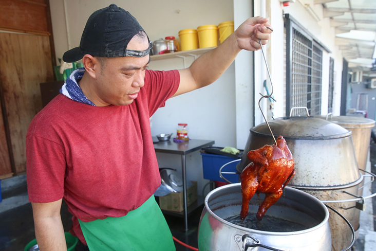  For an even golden colour, Ah Wai will deep fry the whole chickens in oil that has maltose.