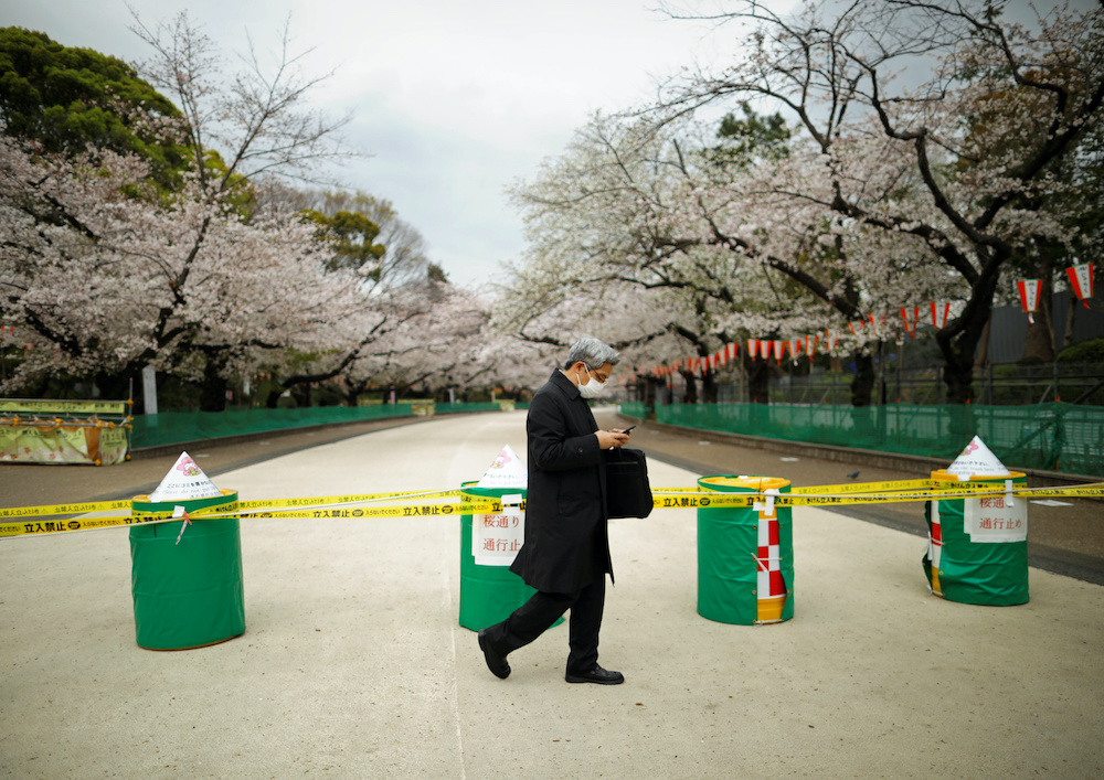 A man wearing a protective face mask, following an outbreak of the coronavirus disease (Covid-19), walks past a closed cherry blossom viewing spot at Ueno park in Tokyo, Japan March 28, 2020. u00e2u20acu201d Reuters pic