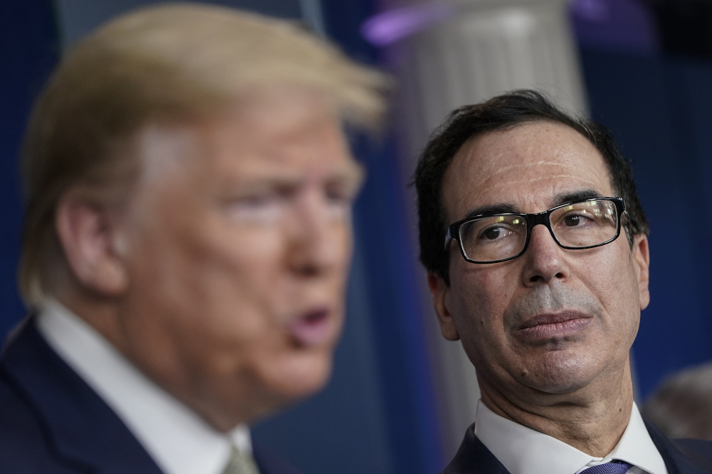 US President Donald Trump speaks as Treasury Secretary Steven Mnuchin looks on during a briefing about the coronavirus outbreak in the press briefing room at the White House March 17, 2020 in Washington, DC. u00e2u20acu201d Drew Angerer/Getty Images pic via AFP