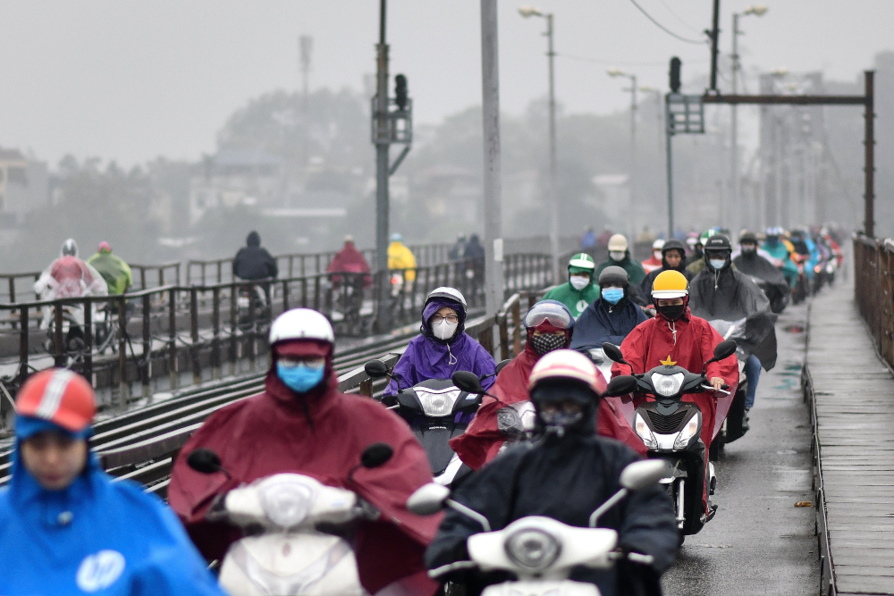 Motorists, wearing facemasks as a preventive measure against the Covid-19 novel coronavirus, ride on a bridge in Hanoi March 17, 2020. u00e2u20acu201d AFP pic 
