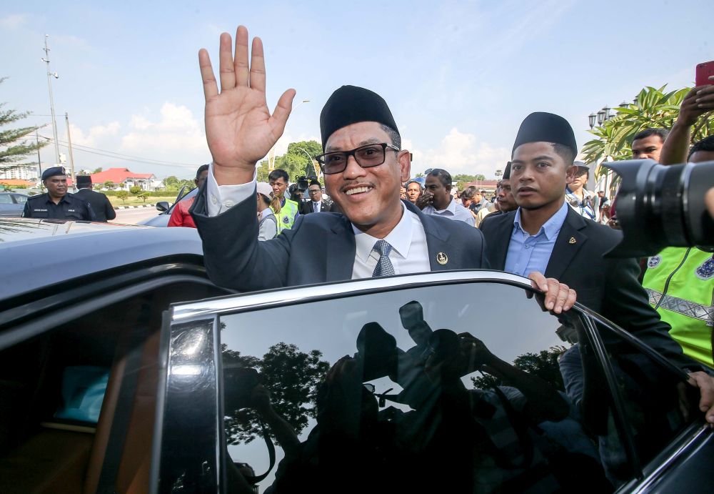 Datuk Seri Ahmad Faizal Azumu waves to reporters as he leaves Istana Kinta March 10, 2020. — Picture by Farhan Najib