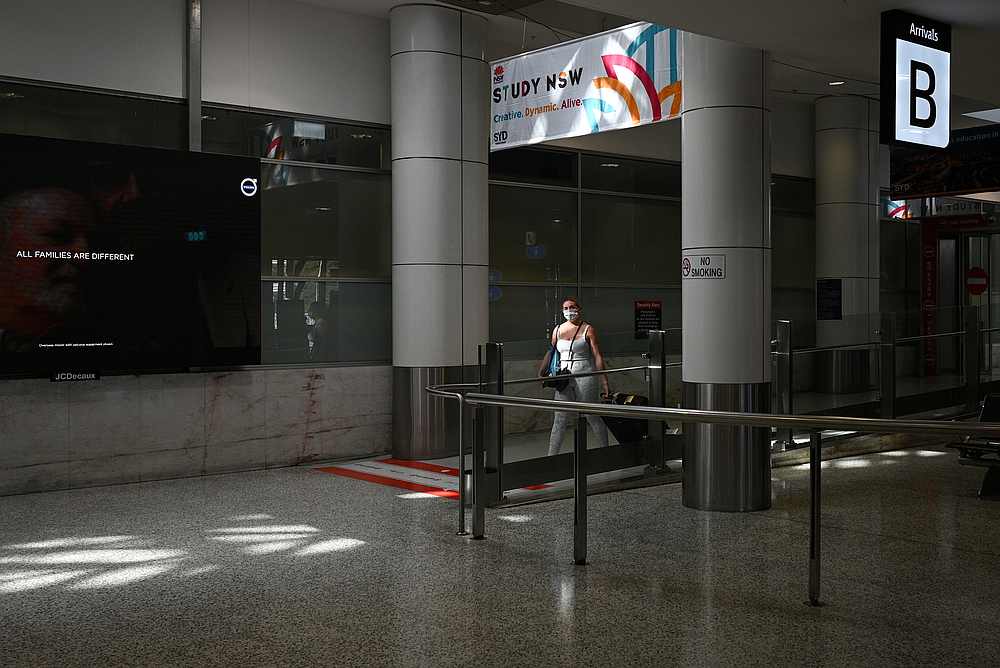 A traveler wearing a protective face mask makes her way through the international terminal of Kingsford Smith International Airport in Sydney, Australia, March 21, 2020. u00e2u20acu201d Reuters pic