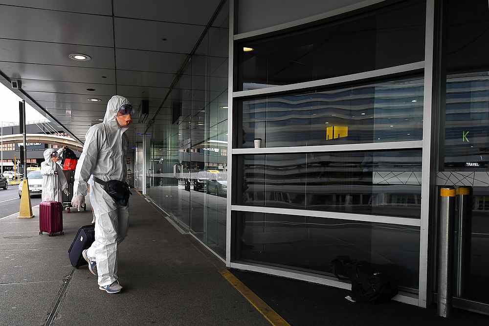 Travellers in personal protective equipment seen at Tullamarine Airport amid rising Covid-19 fears in Melbourne, Australia, March 13, 2020. u00e2u20acu201d AAP Image/James Ross via Reuters 