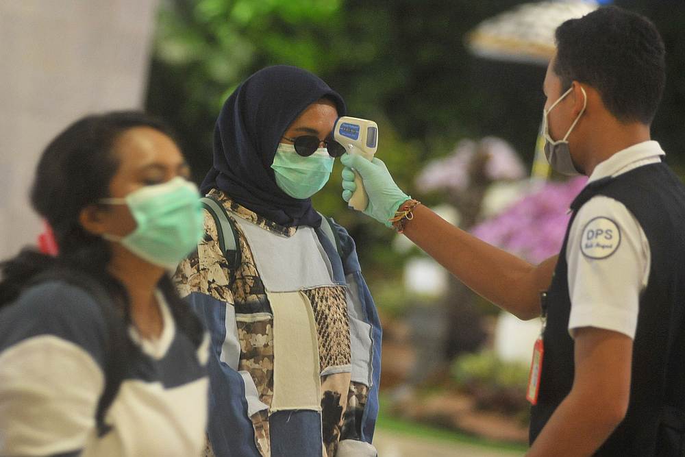 An officer uses a thermal scanner in I Gusti Ngurah Rai International airport in Denpasar, Bali, Indonesia March 10, 2020. u00e2u20acu201d Antara Foto/Fikri Yusuf pic via Reuters