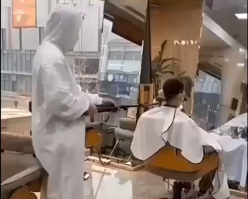 A barber in China shaves his customeru00e2u20acu2122s head using a shaver attached to a long pole while clad in a hazmat suit. u00e2u20acu201d Screengrab from Twitter/@mic12b