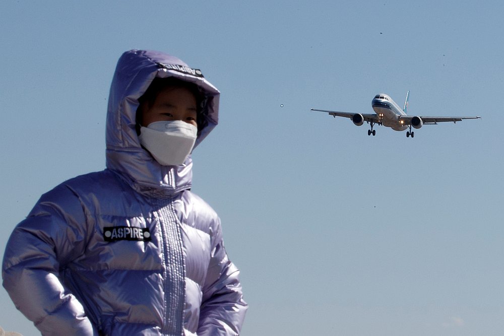 A child wearing a protective mask has her picture taken as a plane of China Southern Airlines lands at Beijing Capital International in Beijing March 13, 2020. u00e2u20acu201d Reuters pic