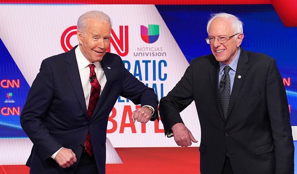 Democratic US presidential candidates Joe Biden (left) and Bernie Sanders do an elbow bumpas they greet other before the start of a debate in CNN's Washington studios without an audience March 15, 2020. u00e2u20acu201d Reuters pic