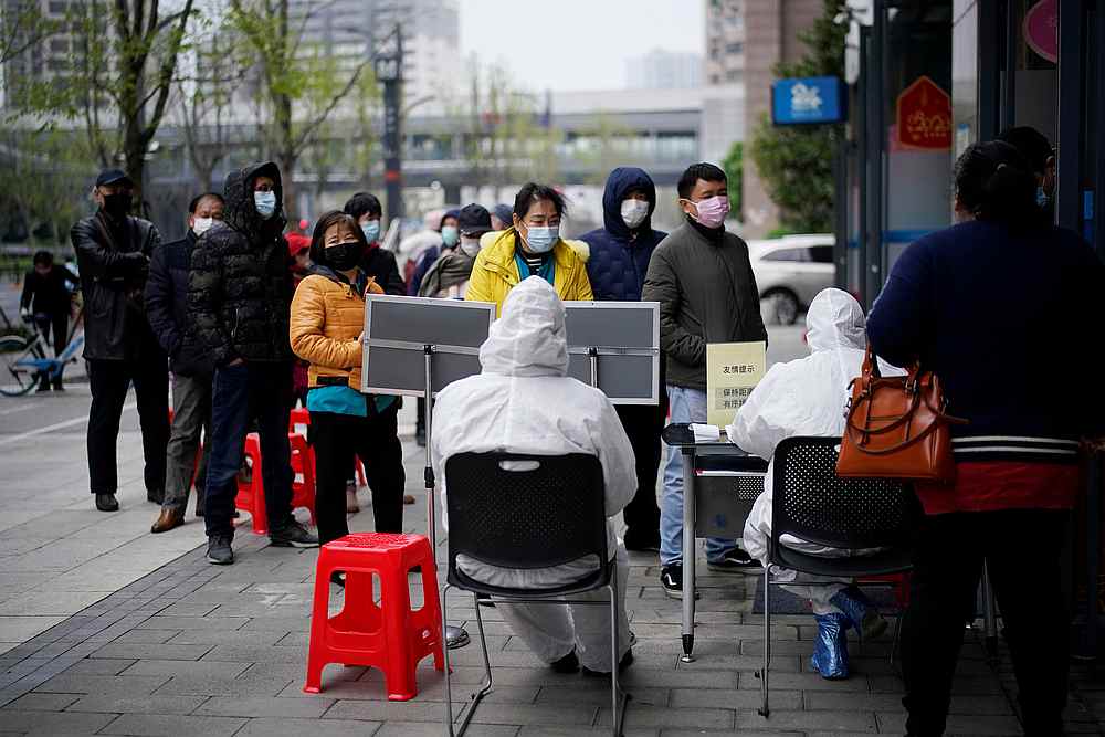 People wearing face masks line up outside a Hankou Bank branch in Wuhan, Hubei province, the epicentre of China's Covid-19 outbreak, March 31, 2020. u00e2u20acu201d Reuters pic