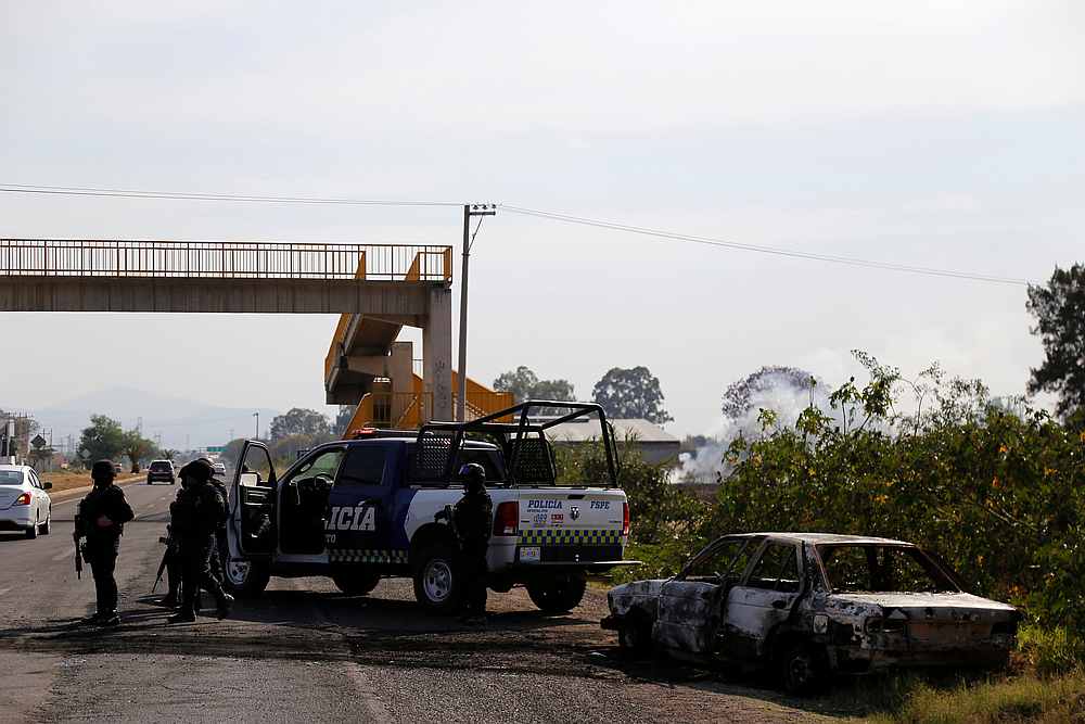 Police stand near the wreckage of a car that was burnt in a blockade set by members of the Santa Rosa de Lima Cartel on the outskirts of Celaya, in Guanajuato state, Mexico March 10, 2020. u00e2u20acu201d Reuters pic