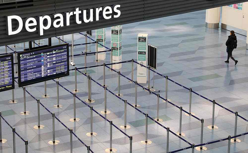 A woman walks near an empty departures gate at Haneda Airport in Tokyo, Japan March 9, 2020. u00e2u20acu201d Reuters pic