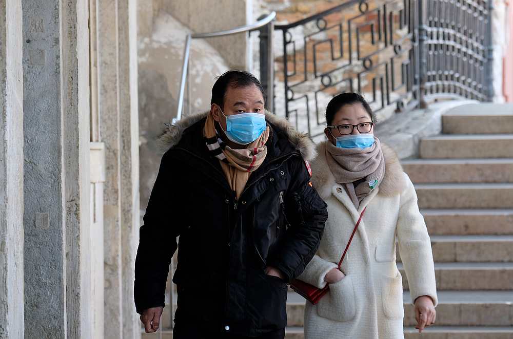 People wearing protective masks are seen in Venice on the second day of an unprecedented lockdown across of all Italy March 11, 2020. u00e2u20acu201d Reuters pic
