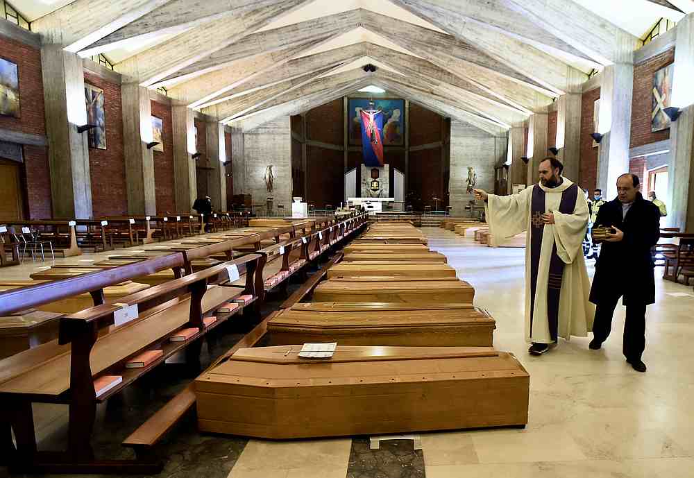 A local priest blesses coffins that have been piling up in a church due to a high number of deaths as Italy struggles to contain the spread of Covid-19 in Seriate, Italy March 28, 2020. u00e2u20acu201d Reuters pic
