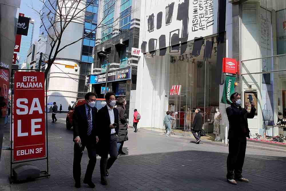 Men, wearing masks to prevent contracting the Covid-19, walk in a shopping district in Seoul, South Korea March 23, 2020. u00e2u20acu201d Reuters pic