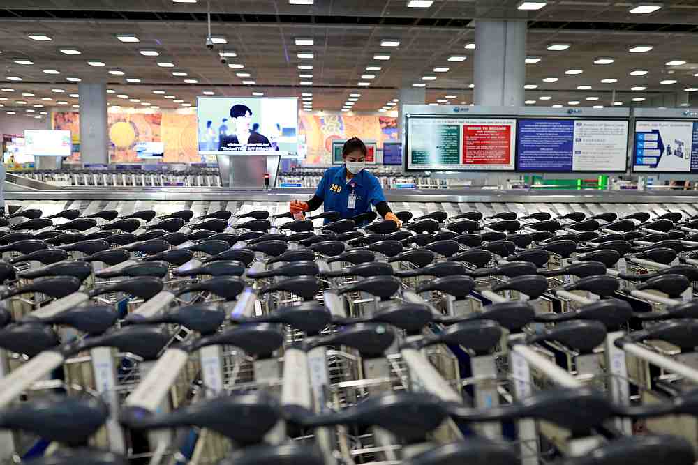 An airport staff member wears a protective mask due to the coronavirus outbreak as she sanitises rows of luggage carts at Suvarnabhumi Airport in Bangkok, Thailand March 12, 2020. u00e2u20acu201d Reuters pic