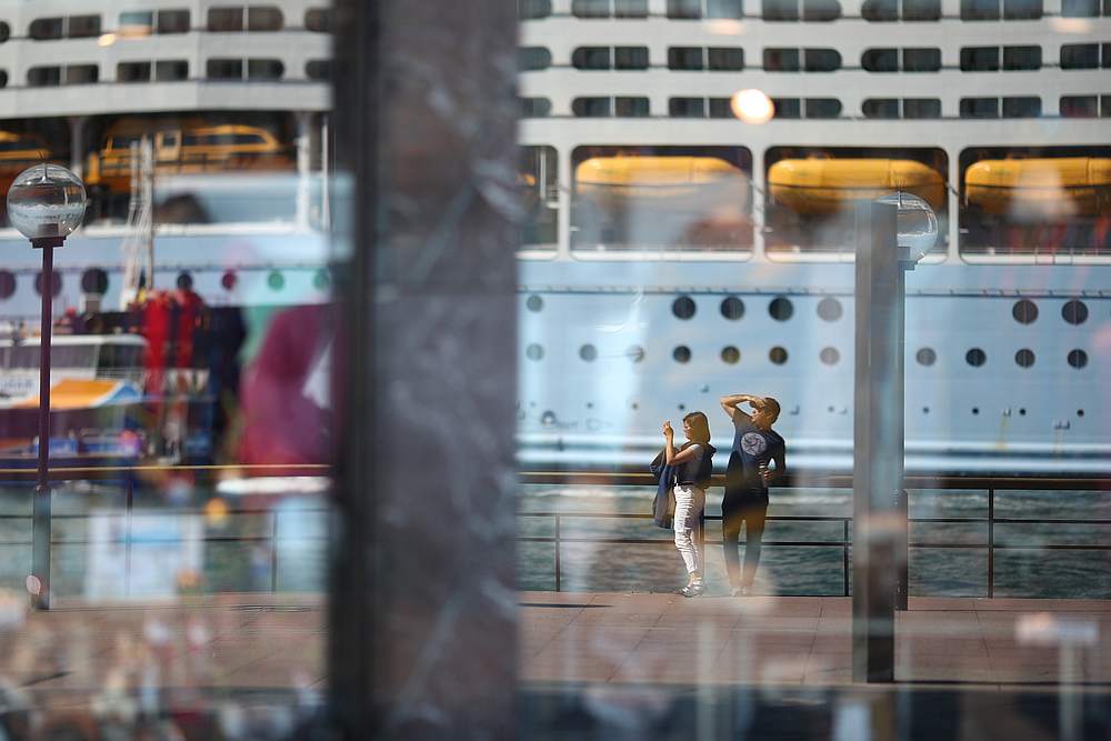 Two people, seen in the reflection of a shop window, stand on the mostly deserted waterfront of the Sydney Opera House, in Sydney, Australia March 18, 2020. u00e2u20acu201d Reuters pic