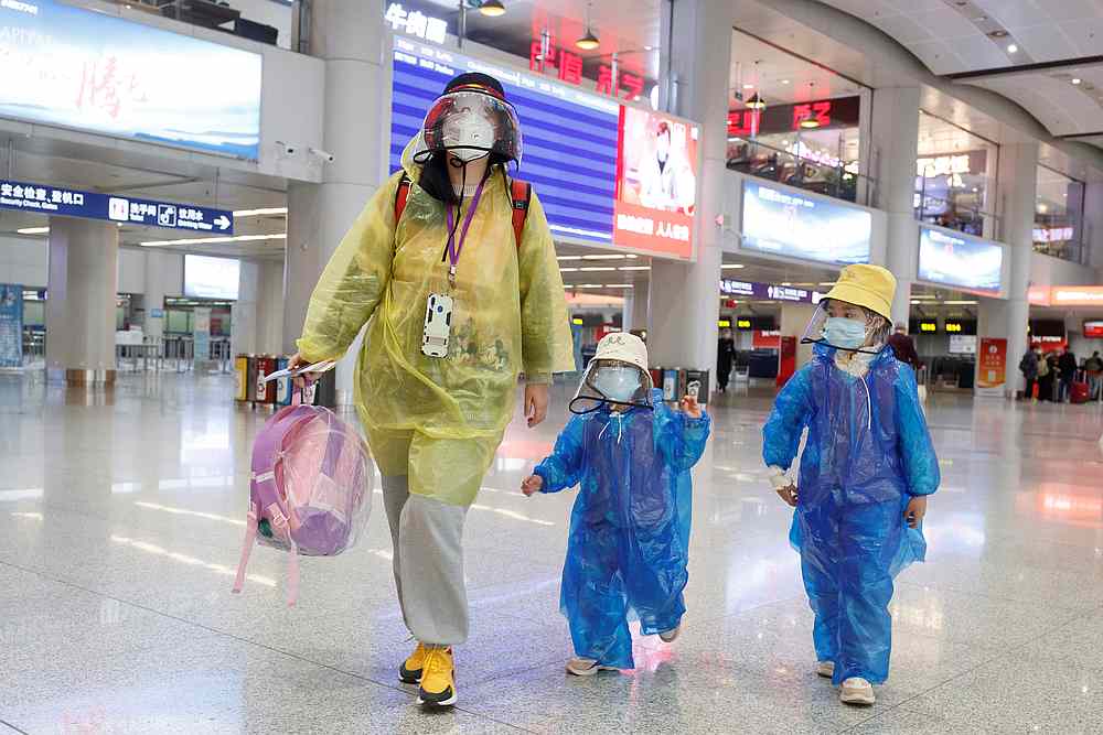 Passengers wearing face masks and raincoats walk through a nearly empty departure hall at Beijing Capital International Airport, China March 9, 2020. u00e2u20acu201d Reuters pic