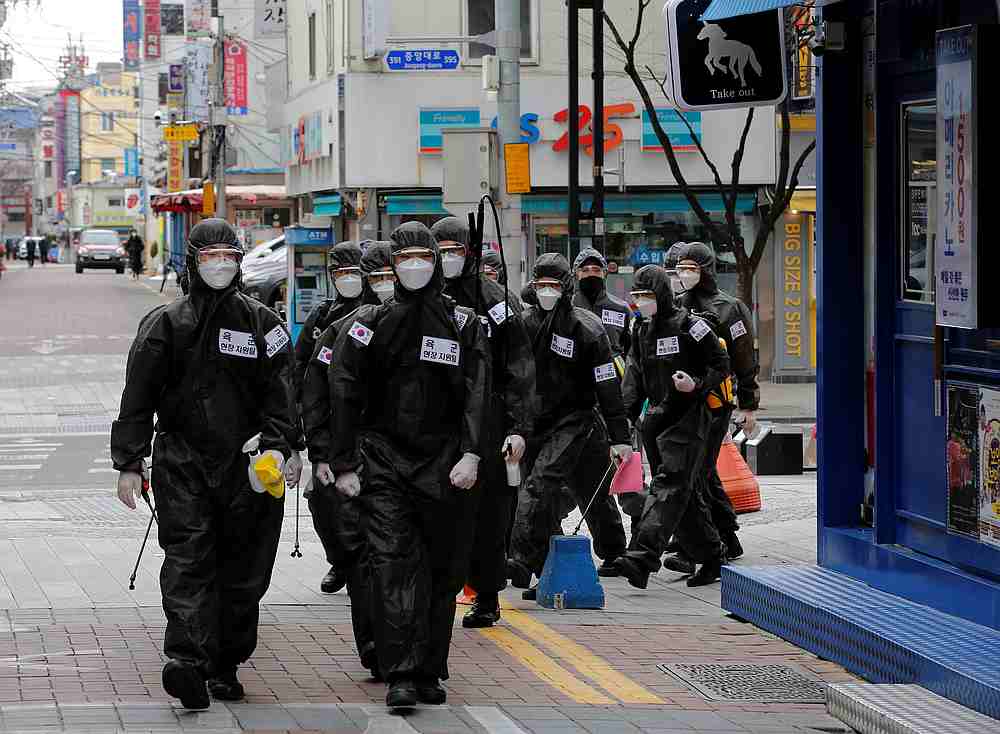 South Korean soldiers in protective gear make their way while they disinfect buildings downtown in Daegu, South Korea March 15, 2020. u00e2u20acu201d Reuters pic
