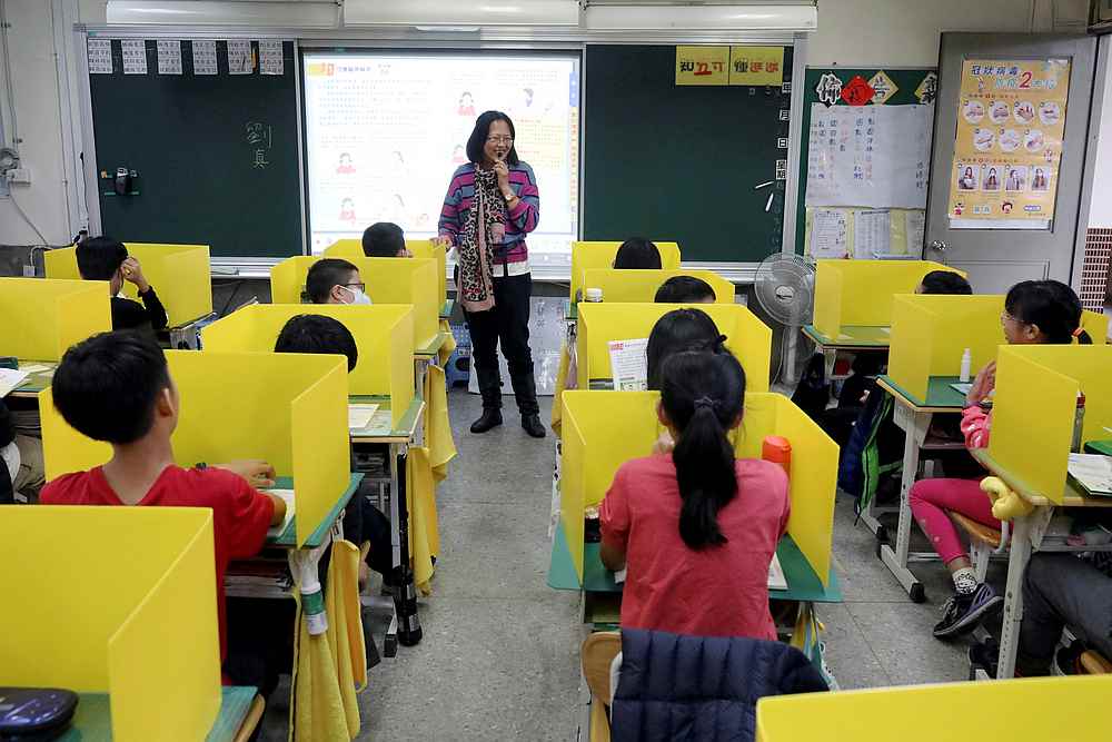 Pupils sit in desks with yellow dividers, set up as a measure against the coronavirus disease, at Dajia Elementary school in Taipei, Taiwan March 13, 2020. u00e2u20acu201d Reuters pic