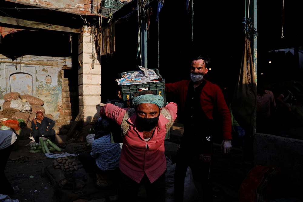 A labourer wearing a mask carries a crate of vegetables in a market during a 21-day nationwide lockdown to limit the spread of Covid-19 in the old quarters of Delhi, India March 26, 2020. u00e2u20acu201d Reuters pic