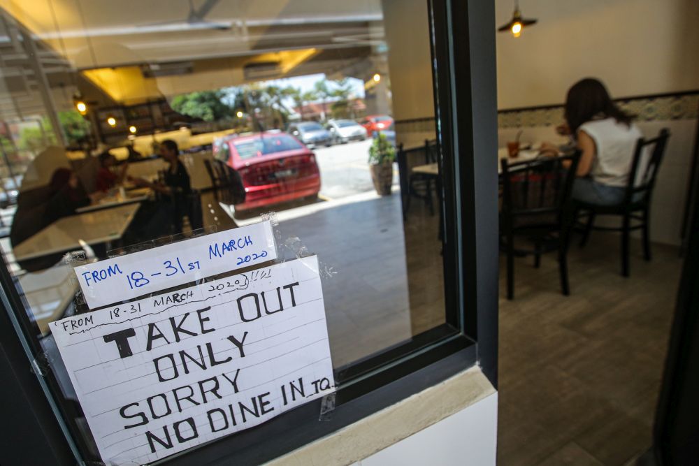 A sign detailing the dining restriction is pictured at Campbell Street Cafe  in Kota Damansara March 17, 2020. — Picture by Hari Anggara