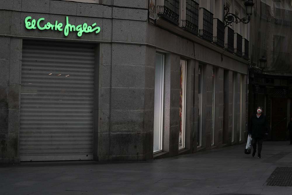 A woman wearing a protective mask walks past a closed down El Corte Ingles department store during partial lockdown to combat the Covid-19 outbreak, in Madrid, Spain March 15, 2020. u00e2u20acu201d Reuters pic