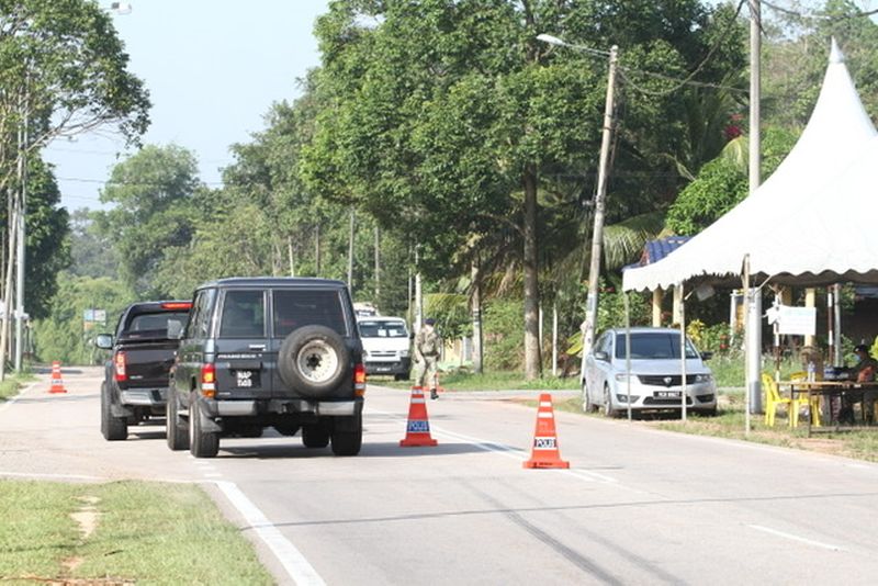 Police man roadblocks on the trunk roads leading to the two affected areas in Simpang Renggam that have since been under the enhanced movement control order. u00e2u20acu201d Picture by Ben Tan