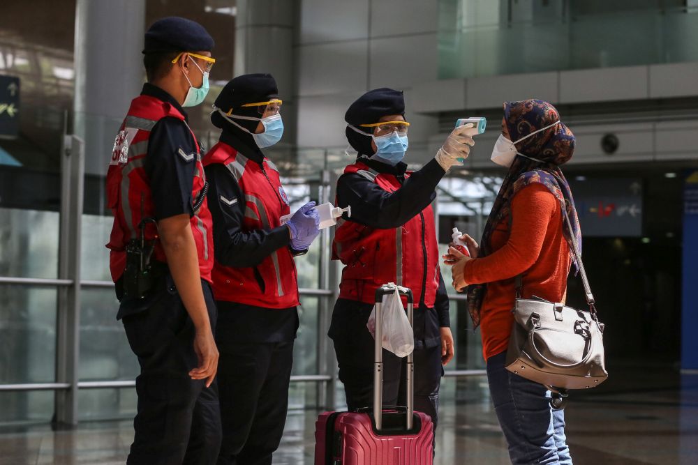 Personnel from the Emergency Response Team screen members of the public at KL Sentral March 20, 2020. u00e2u20acu2022 Picture by Yusof Mat isa