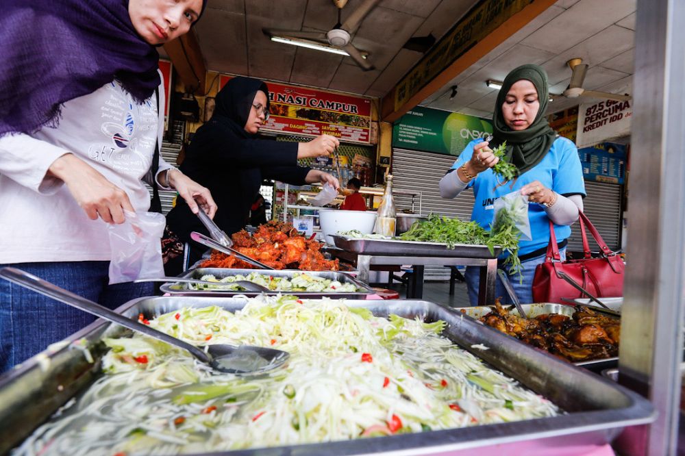 Customers pack food to go at a food court in Penang March 18, 2020. u00e2u20acu201d Picture by Sayuti Zainudin