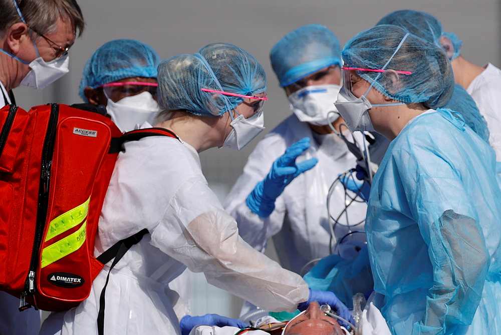 French rescue team wearing protective suits carry a patient on a stretcher from Mulhouse hospital before being loaded into a helicopter March 23, 2020. u00e2u20acu201d Reuters pic