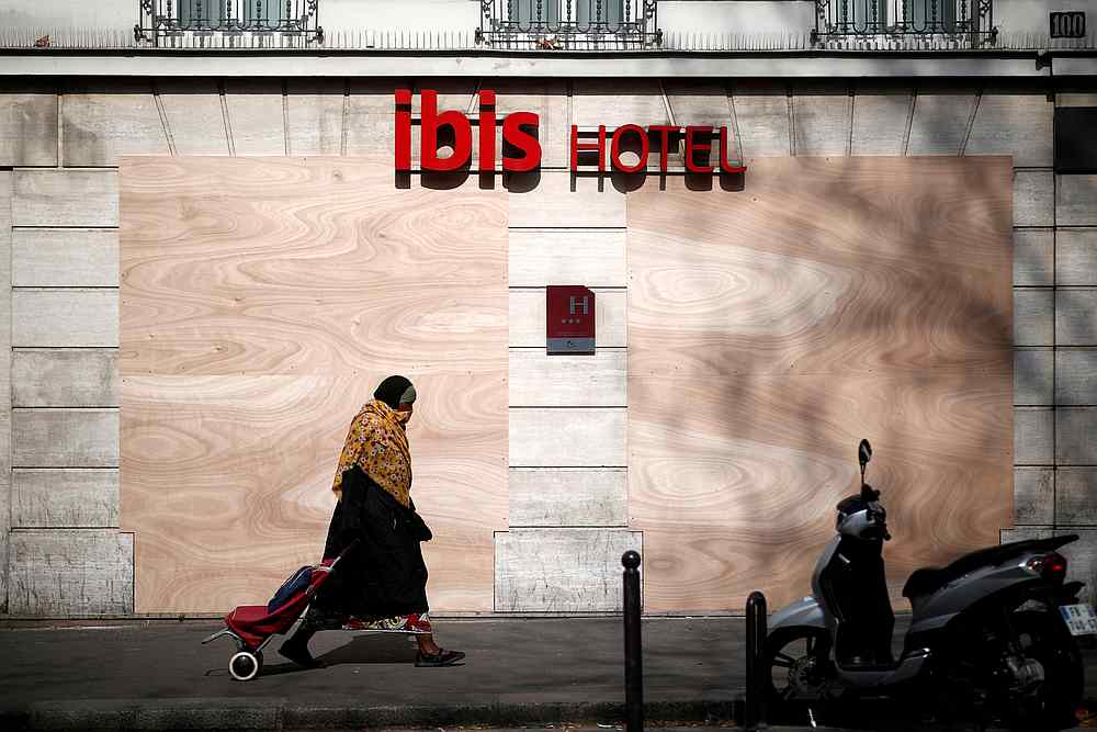 A woman passes by a closed main entrance of an Ibis hotel as a lockdown is imposed to slow down the spread of Covid-19 in France March 28, 2020. u00e2u20acu201d Reuters pic