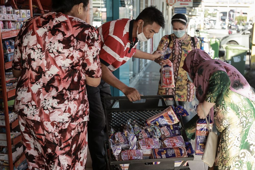A Gardenia staff unloads fresh loaves of bread at a convenience store in Petaling Jaya March 25, 2020. u00e2u20acu201d Picture by Ahmad Zamzahuri