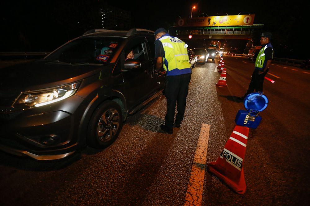 Police personnel check vehicles during a roadblock in George Town March 19, 2020. — Picture by Sayuti Zainudin