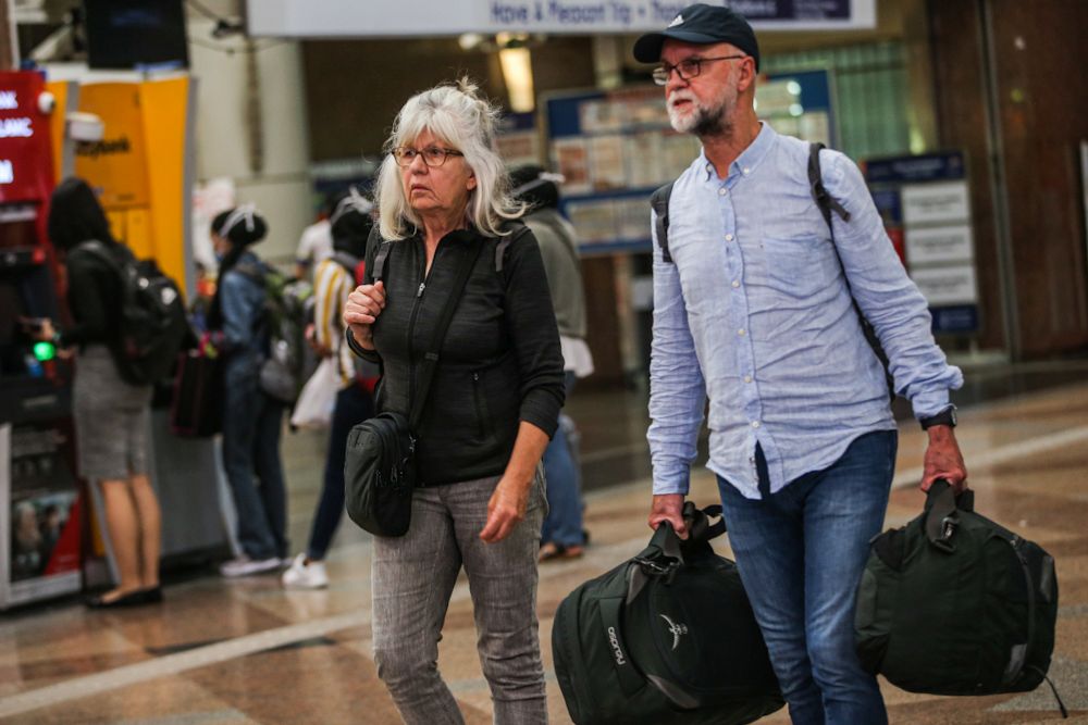 German tourists Joachim (right) and Margit Hommes are pictured at KL Sentral, Kuala Lumpur as the movement control order kicks in on March 18, 2020. u00e2u20acu201d Picture by Hari Anggara