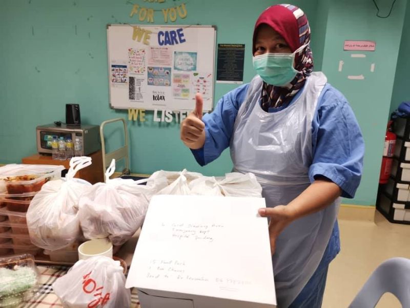 A staff member at Serdang Hospital posing with the hot meals delivered by GoJob. u00e2u20acu201d Picture via Facebook/gojobmalaysia