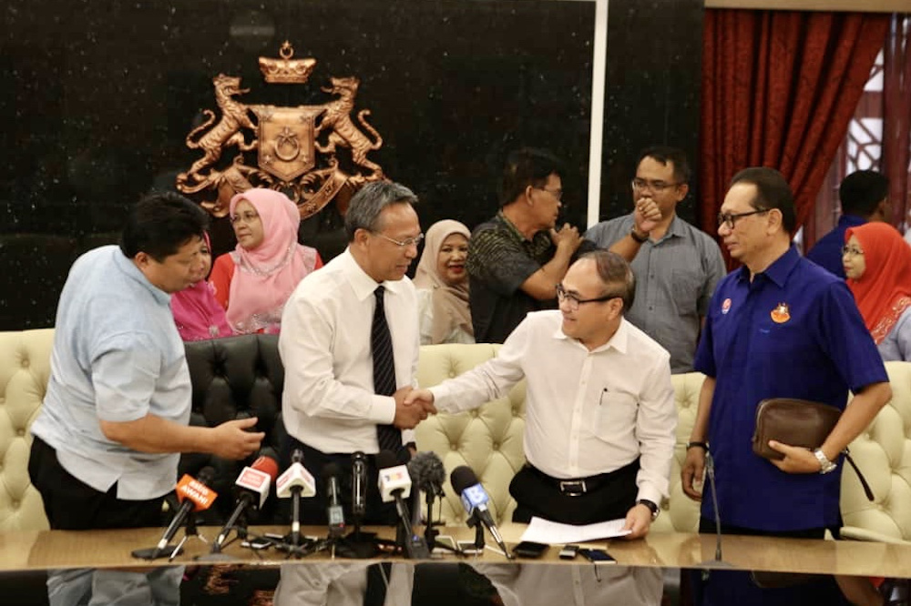 Johor Mentri Besar Datuk Hasni Mohammad thanks Pemanis state assemblyman Dr Chong Fat Full (centre) for supporting the new Gabungan Baharu state government at the Johor Mentri Besar's Office March 4, 2020. — Picture by Ben Tan